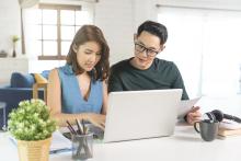 serious-asian-husband-checking-analyzing-statement-utilities-bills-sitting-together-home